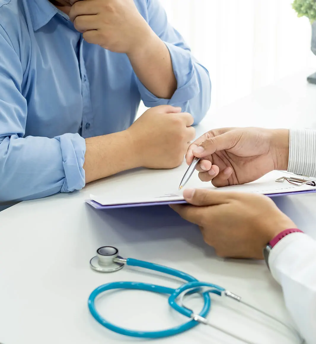 Ein Arzt erklärt einem Mann während eines Beratungsgesprächs zur Vasektomie ein Formular